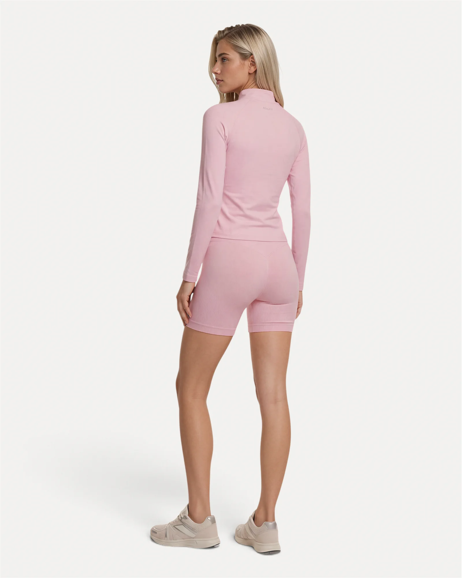Back lifestyle view of soft pink Realfit lightweight zip jacket for women