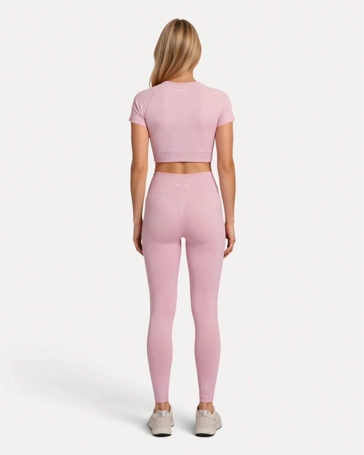 Back lifestyle view of soft pink Realfit Core short-sleeve crop top for women