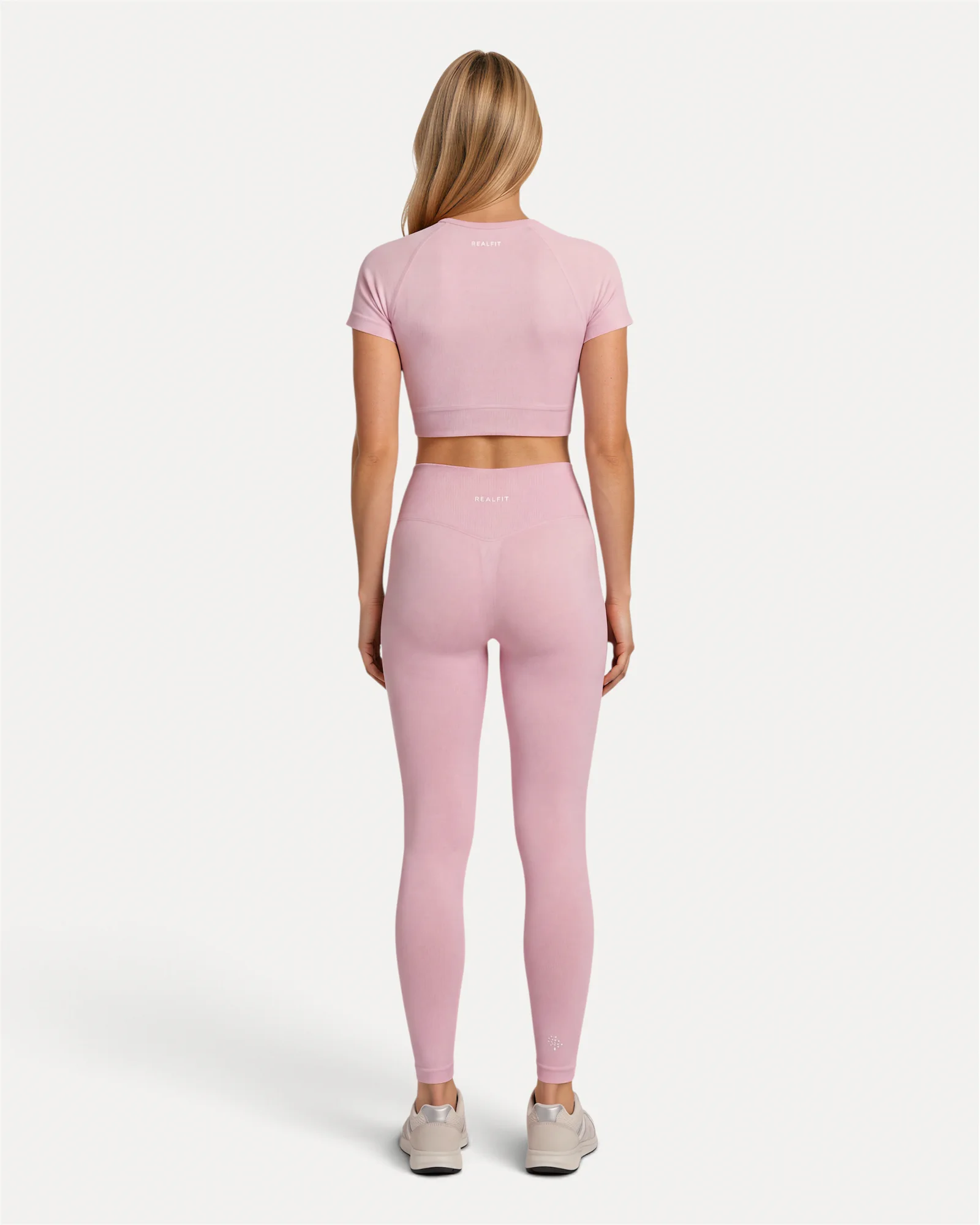Back lifestyle view of soft pink Realfit Core short-sleeve crop top for women